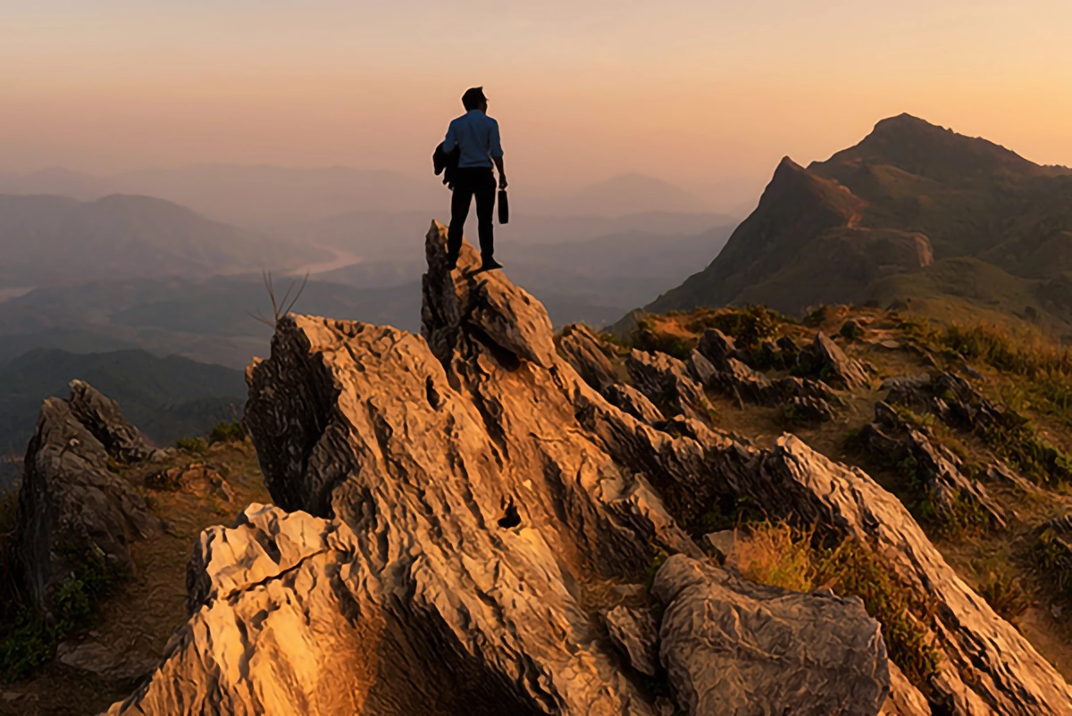 Image of a person on a mountain during a sunset